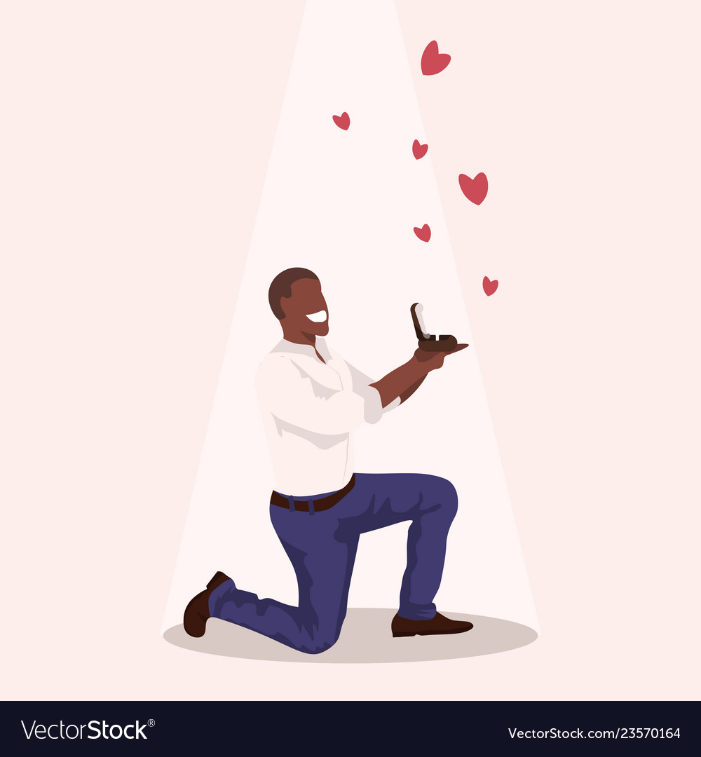 Man kneeling holding engagement ring proposing