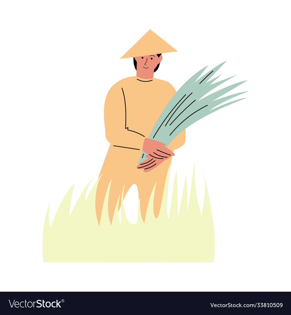 Asian farmer standing in grass and holding freshly