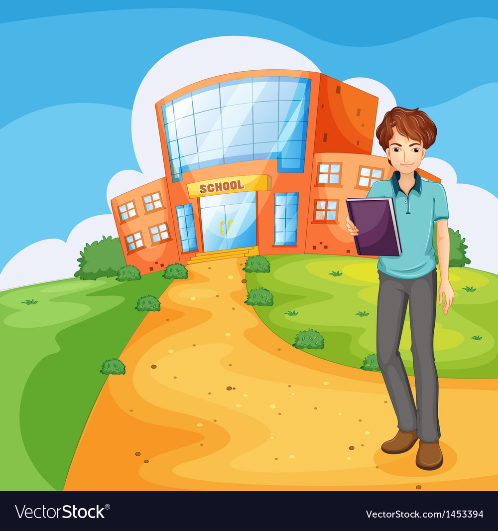 A boy holding book standing outside the school