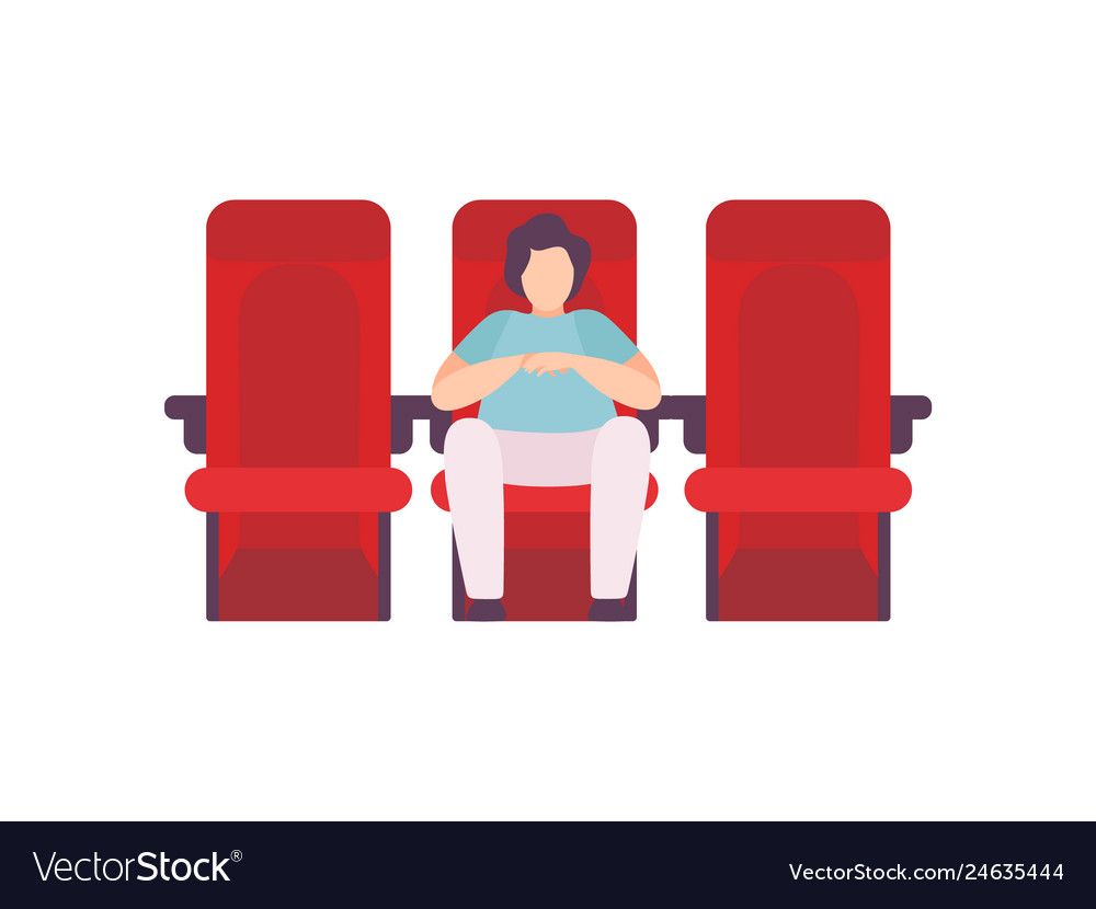 Young man sitting in cinema theatre and watching