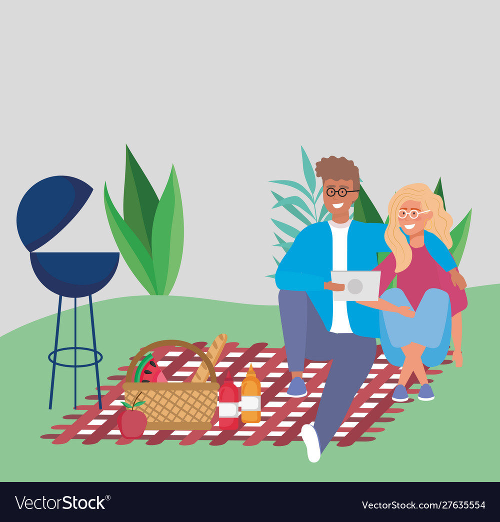 Couple sitting on blanket picnic basket food grill