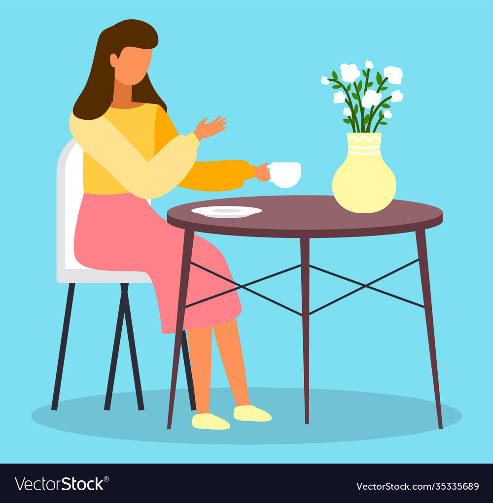 Woman sits at round coffee table and drinks tea