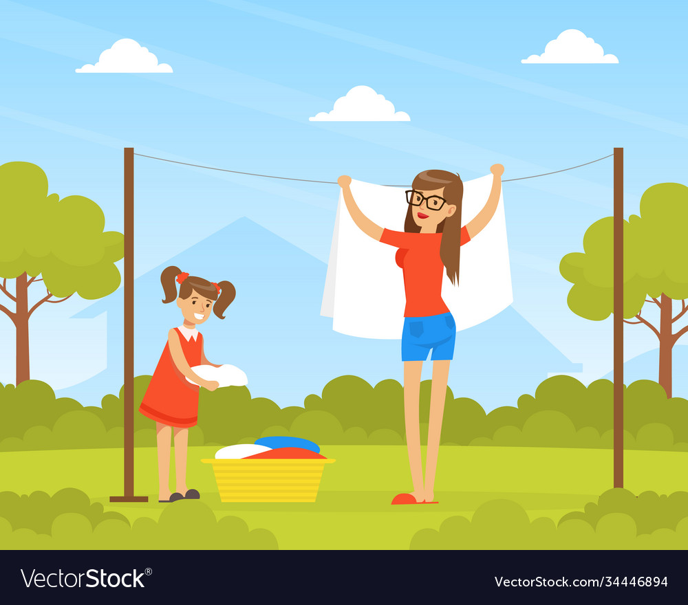 Mother and daughter hanging wet clothes out to dry