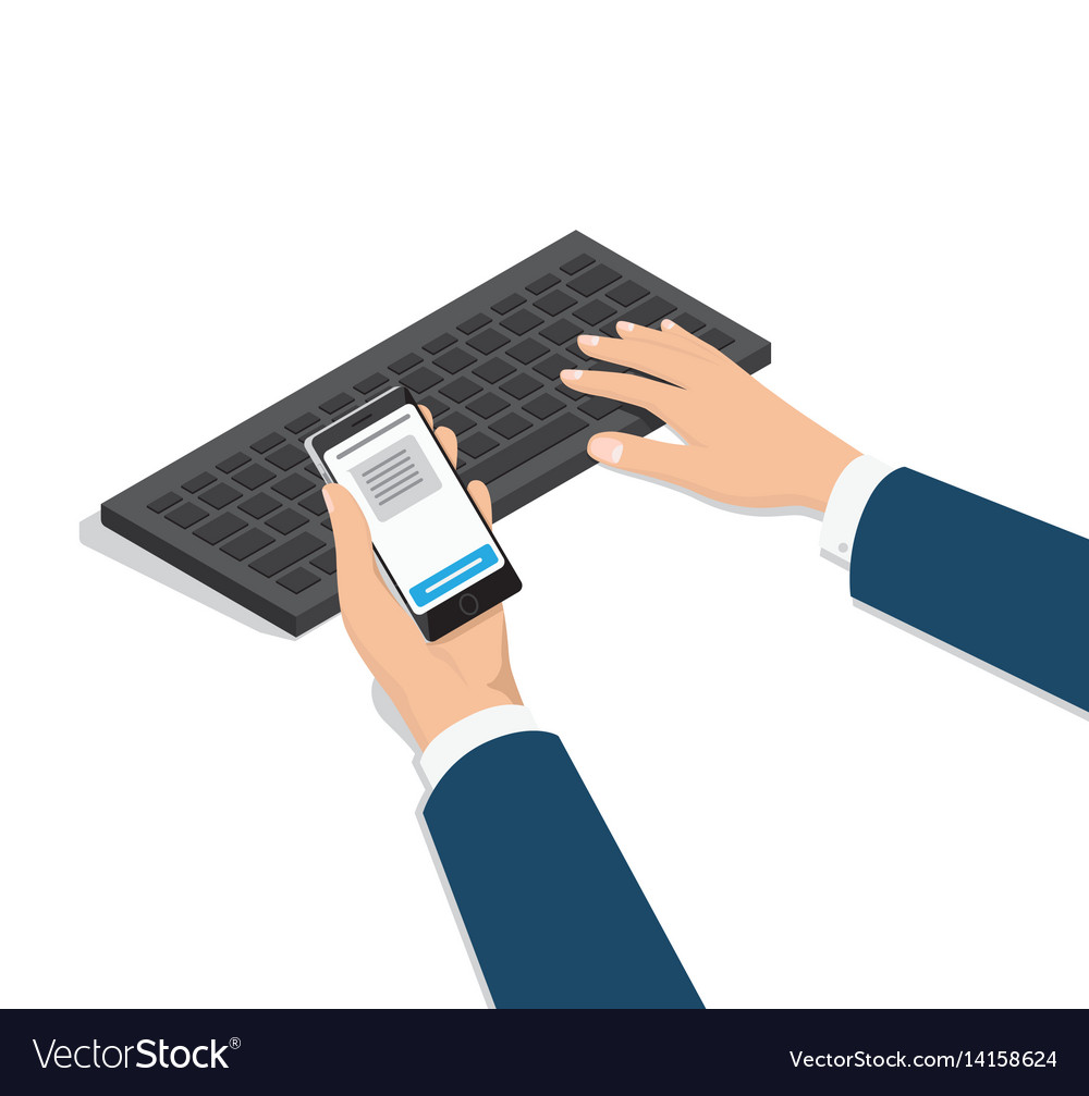 Man typing on computer with phone in hand