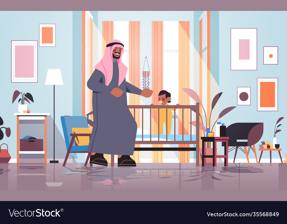 Arab father playing with little son in crib