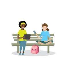 Two Teen Girls With Gadgets Are Sitting