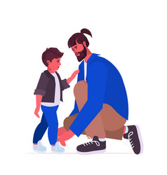 Young Father Tying Laces On Child Boots