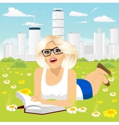 Woman Lying Down On Grass Reading Book