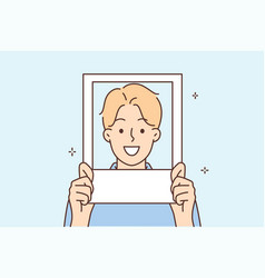 Smiling Man Holds Photo Near Face And Poses