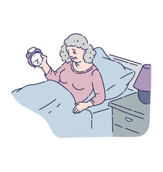 Tired Senior Woman Lie In Bed And Hold Alarm Clock