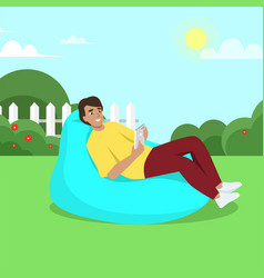 Young Man Sits On Bean Bag With Gadget Work