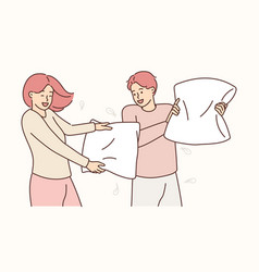 Smiling Couple Involved In Pillow Fight