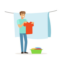 Young Smiling Man Hanging Wet Clothes Out To Dry