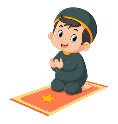 A Cute Muslim Boy Is Praying On His Prayer Mat