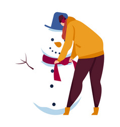 Woman Building Snowman In Winter Wearing Hat And