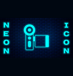 Glowing Neon Cinema Camera Icon Isolated On Brick