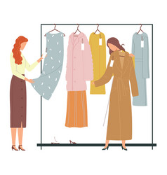 Two Women Shopping For Clothes Examining A Dress