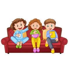 Three Happy Kids Eating Snacks On Sofa