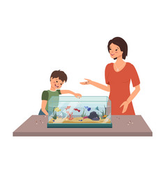 Mom And Boy Feed Fish In Aquarium