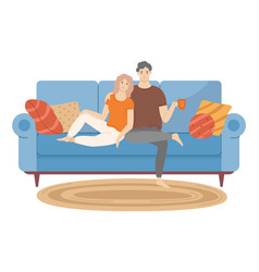 Couple Sitting On Sofa Cuddling And Drinking Tea