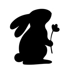 Bunny Is Sitting And Holding A Flower Image