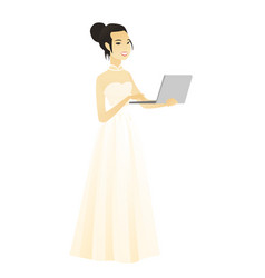 Asian Bride In A White Dress Using A Laptop