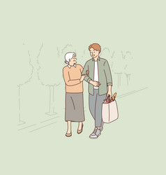 Young Man Helps Old Woman To Carry Heavy Bag From