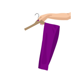 A Womans Hand Holds Pants On Hanger