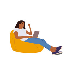 Black Woman Working On Laptop In Bean Bag Chair