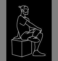 Man Sitting On Cube With One Foot Up On Knee