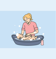 Smiling Mother Washing Newborn Baby