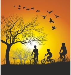 Family Cycling In The Countryside At Sunset