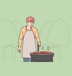 Man In Apron Cook Meat Outdoors