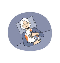 Smiling Old Woman Lying In Bed With Cat On Chest