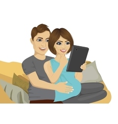 Young Pregnant Couple Using Tablet Computer