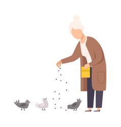 Senior Woman Standing And Feeding Pigeons