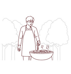 Man In Apron Cook Meat Outdoors