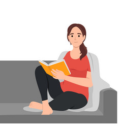 Young Woman Reading Book On Sofa At Home