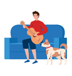 Young Man Playing Guitar Sitting A Couch With Dog