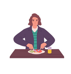 Young Man Sitting At Dining Table Eating Meat