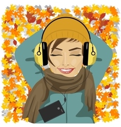 Woman Listening To Music Lying On Autumn Leaves